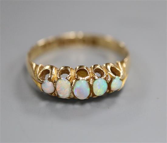 An Edwardian 18ct gold and graduated five stone white opal half hoop ring, size O.